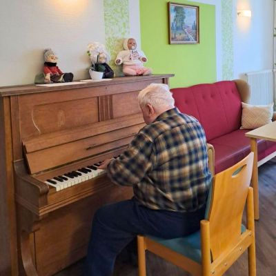 Haus Kreuzstift alter Mann spielt Klavier